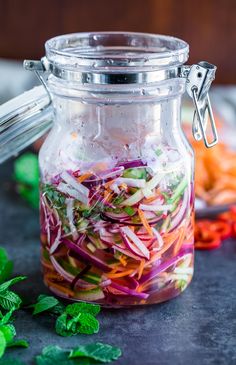 a jar filled with sliced vegetables on top of a table