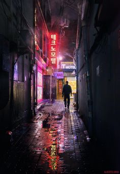 a man walking down an alley way at night with neon signs on the buildings behind him