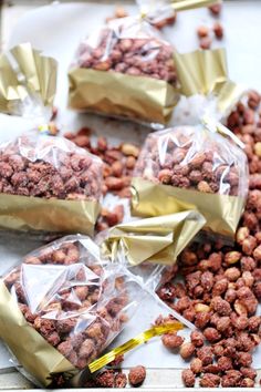 several bags of nuts are sitting on a table with some gold foil wrapped around them