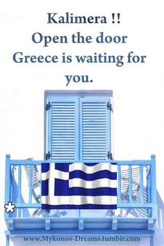 a blue balcony with shutters and a towel on it that says kalmera open the door greece is waiting for you