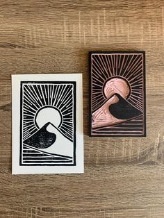 two cards with designs on them sitting next to each other, one is black and the other is white