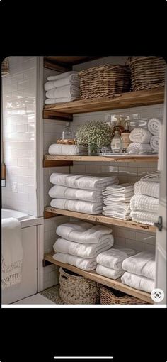 the shelves in this bathroom are filled with white towels