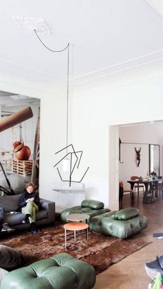 a living room filled with lots of furniture next to a painting on the wall and floor