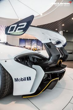 a white and black sports car on display in a building