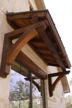 an arch made out of wood on the side of a building next to a window