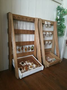 two wooden boxes with necklaces in them sitting on the floor next to each other