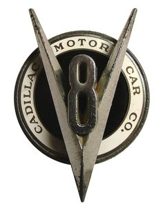 the emblem for an automobile company is shown in black and white, as well as two large metal scissors