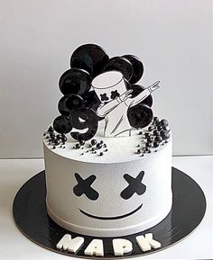 a white cake decorated with black and white decorations