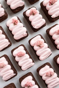 there are many brownies with pink frosting on them