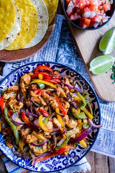 a plate full of chicken fajita with tortillas and salsa on the side