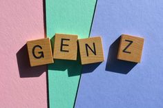 the word genz spelled with scrabble blocks on top of pastel colored paper