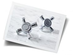 two silver objects sitting on top of a white table