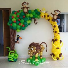 balloon decorations are displayed in the shape of animals, trees and monkeys on a wall