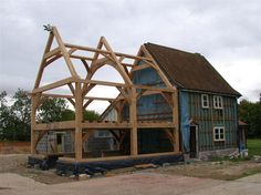 a house being built in the middle of an open lot with wood framing on it