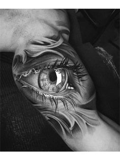 an eye tattoo on the arm is shown in this black and white photo, it looks like