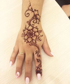 a woman's hand with henna tattoos on it