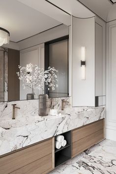 a bathroom with marble counter tops and wooden cabinets, along with a vase filled with flowers