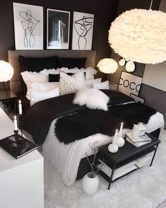 a black and white bedroom with candles on the nightstands in front of the bed