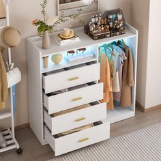 a white dresser with drawers and clothes on it