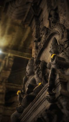 carvings on the side of a building with light shining in the backgroung