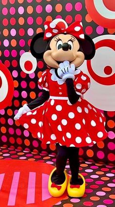 the minnie mouse is posing for a photo in front of polka dot wallpapers