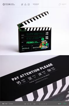 a black and white business card sitting on top of a wooden table next to a movie clapper