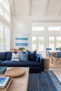 a living room filled with blue furniture and lots of windows in the wall behind it