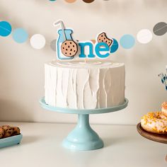 a birthday cake sitting on top of a table next to cookies and cupcakes