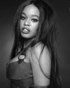 a black and white photo of a woman with very long hair wearing a leather outfit