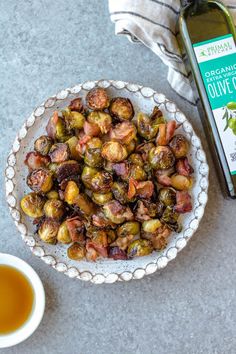 roasted brussel sprouts in a bowl next to a bottle of olive oil