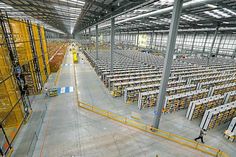 a large warehouse filled with lots of yellow and white shelves next to eachother