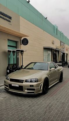 a gold car parked in front of a building