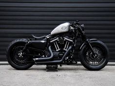 a black motorcycle parked in front of a garage door