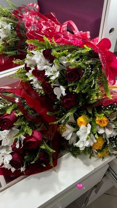 a bunch of flowers that are on top of a table in front of a mirror