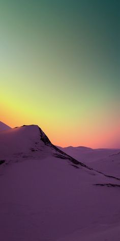 the sun is setting over a snowy mountain