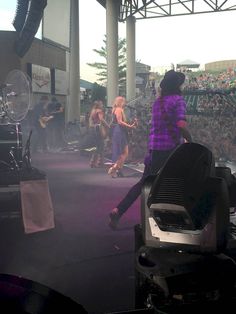 a group of people standing on top of a stage in front of a large crowd