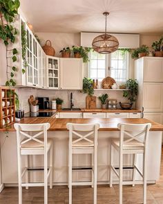 the kitchen is clean and ready to be used for cooking or eating, with three stools in front of the island