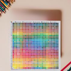 a color chart with colored pencils next to it