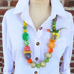 a woman wearing a white shirt and colorful beaded necklace