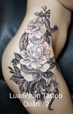 a woman's stomach with flowers and snake tattoo on the side, which reads luanphan tattoo quann 1 2