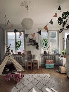 a child's room with a teepee tent and toys in the foreground