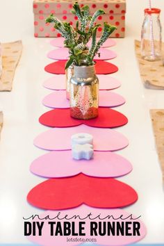 a table that has some paper hearts on it and a potted plant in the middle