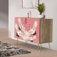 a pink cabinet with two birds painted on it