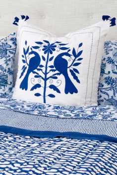 a blue and white bed with two birds on it