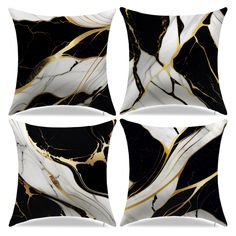 four black and white marble pillows with gold accents on them, each one has a square shape