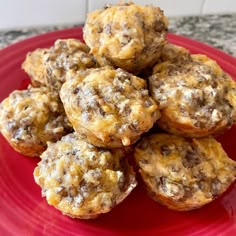 a red plate topped with muffins on top of a counter