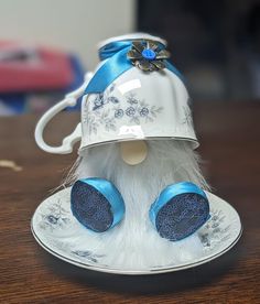 a white and blue tea cup sitting on top of a saucer covered in frosting