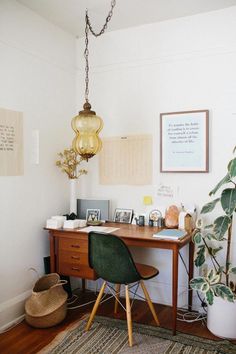 a room with a desk, chair and potted plant