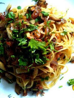 a white plate topped with pasta and mushrooms