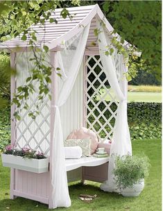 a pink and white gazebo sitting on top of a lush green field